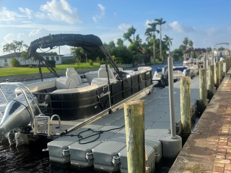 Black Bentley 24' Tritoon rental boat tied up at a floating dock in Cape Coral