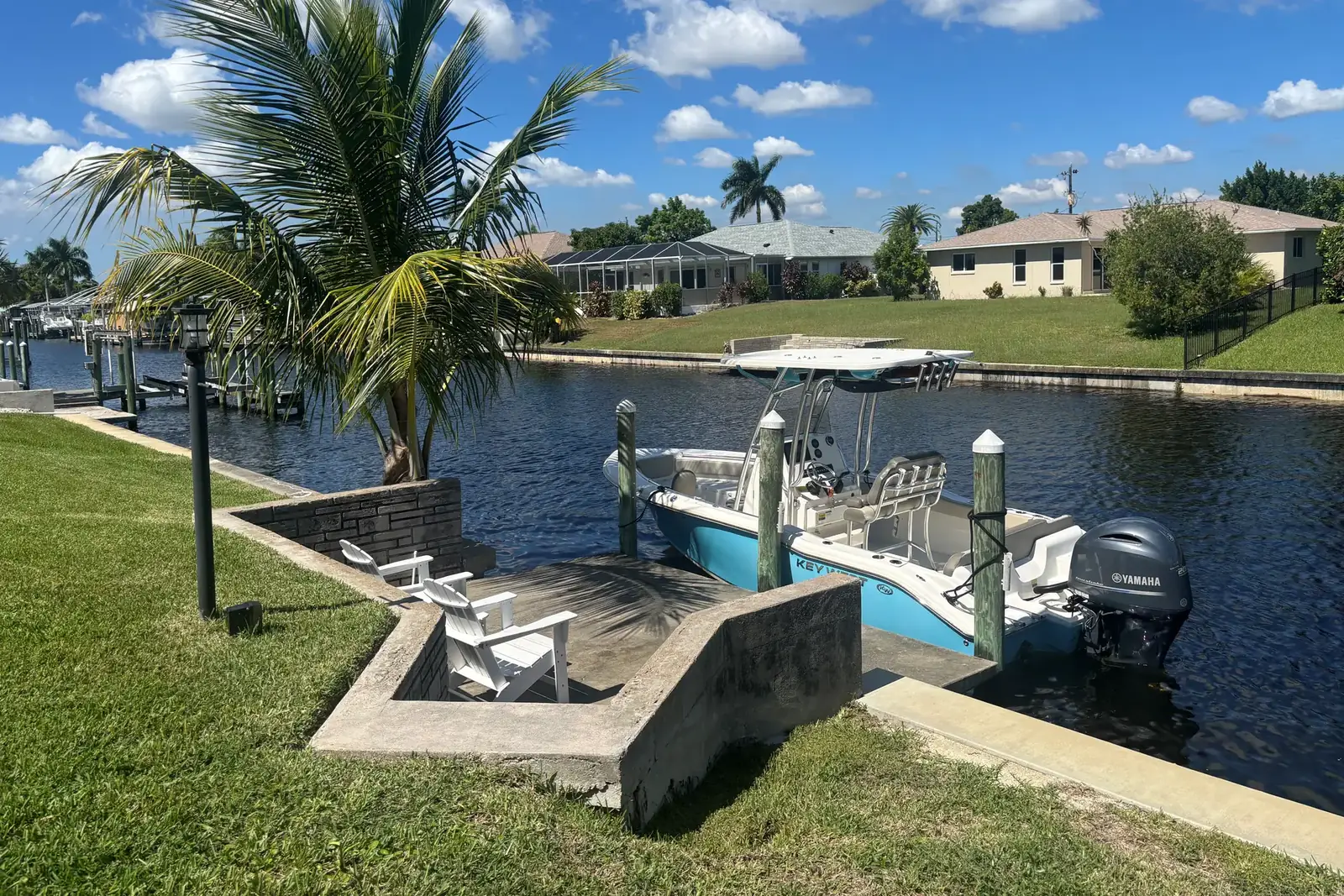 Center console boat waiting at the private dock of a canal-front home in Southwest Florida