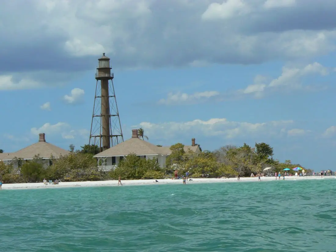 Lighthouse above a white-sand beach and turquoise water in Sanibel, FL