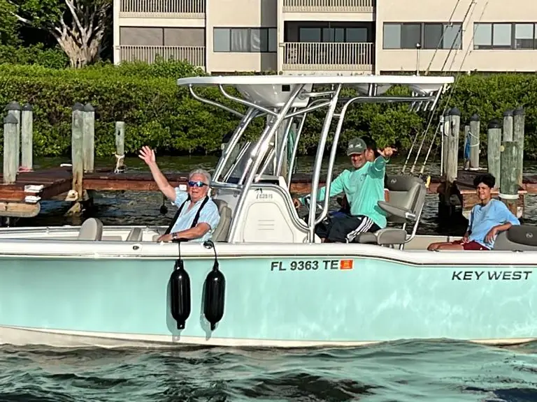 Three guests waving from a Key West center console at the dock in Southwest Florida