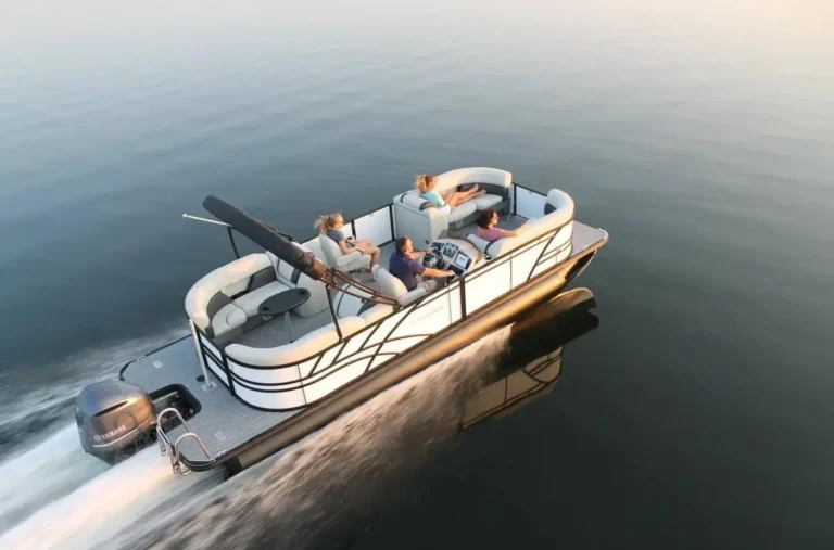 Tritoon boat cruising on calm water with four aboard